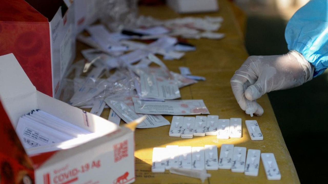 A health worker collects swab samples from people during a Covid-19 coronavirus screening. Credit: AFP Photo