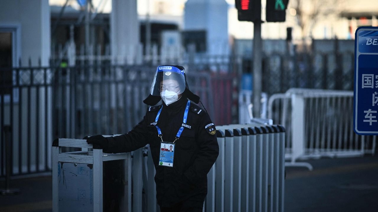 A security personnel stands next to a fence at a checkpoint to enter the closed-loop bubble - created as a preventative measure against the Covid-19 coronavirus - on February 3, 2022, in Beijing ahead of the 2022 Beijing Winter Olympic Games. Credit: Reuters Photo