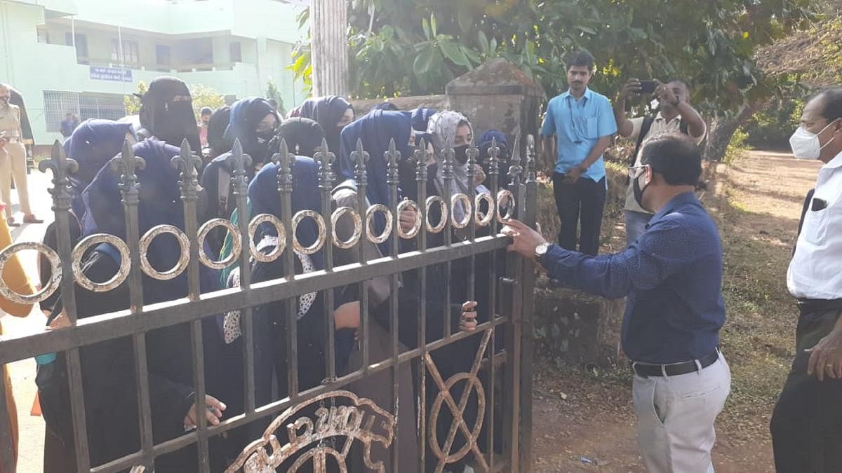 Hijab-clad students of the Kundapura Govt Junior College barred from entering the campus on Thursday. DH photo