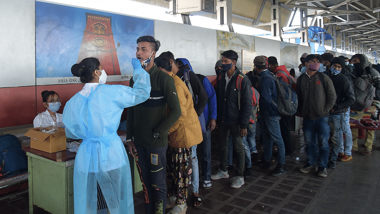 A health worker takes a swab sample from a passenger to test for the Covid-19.  Credit: AFP Photo