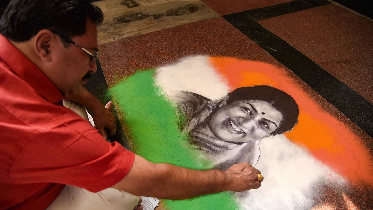 Artist Shreehari Pavale makes a 'rangoli' art to pay homage to legendary singer Lata Mangeshkar, at Vashi, Mumbai. Credit: PTI Photo