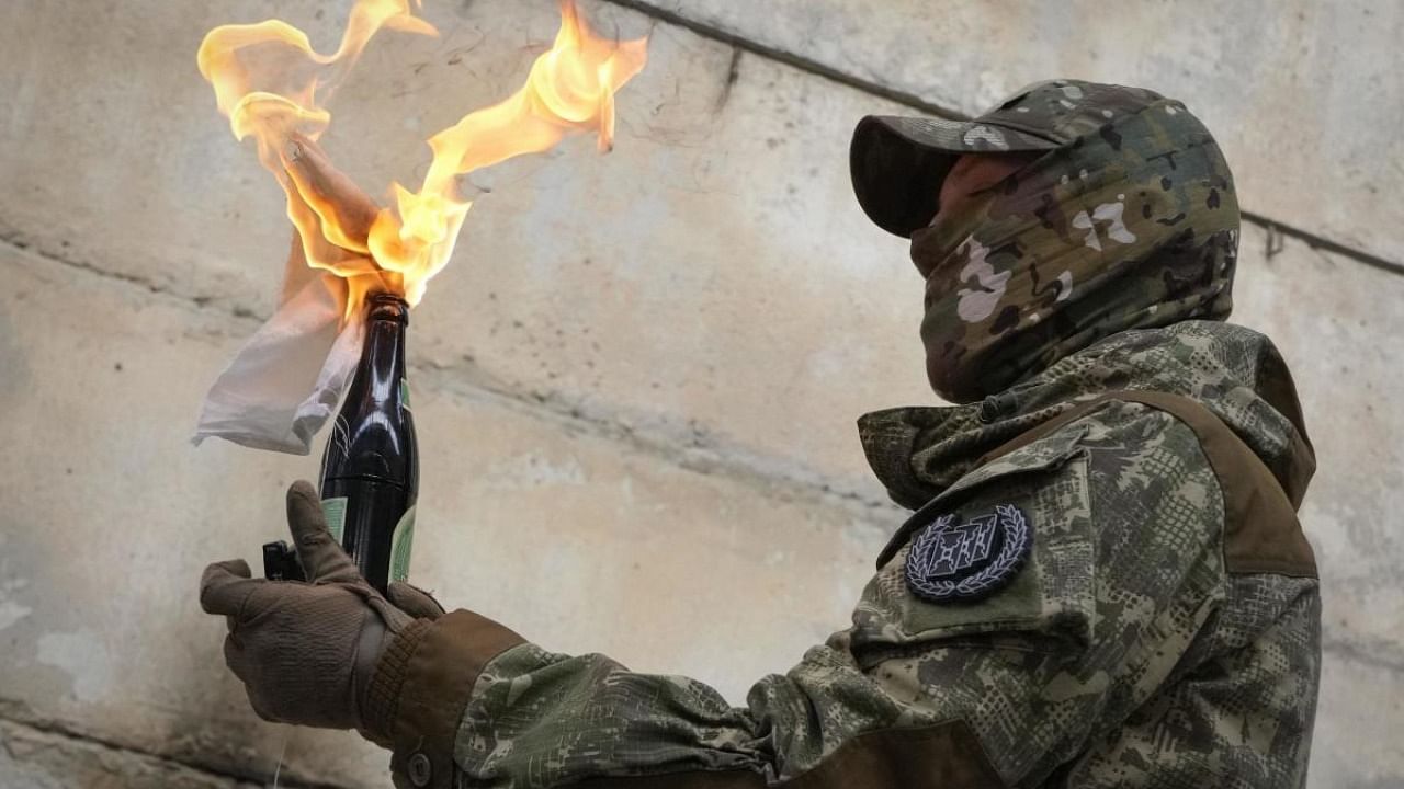  A local resident prepares to use a Molotov cocktail against a wall during an all-Ukrainian training campaign "Don't panic! Get ready!" close to Kyiv. Credit: AP/PTI photo