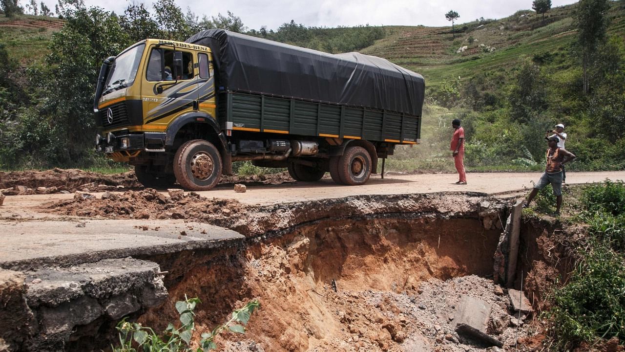 Residents look at the partially collapsed RN25 road in Ranomafana on February 7, 2022 following the passage of cyclone Batsirai. Credit: AFP Photo