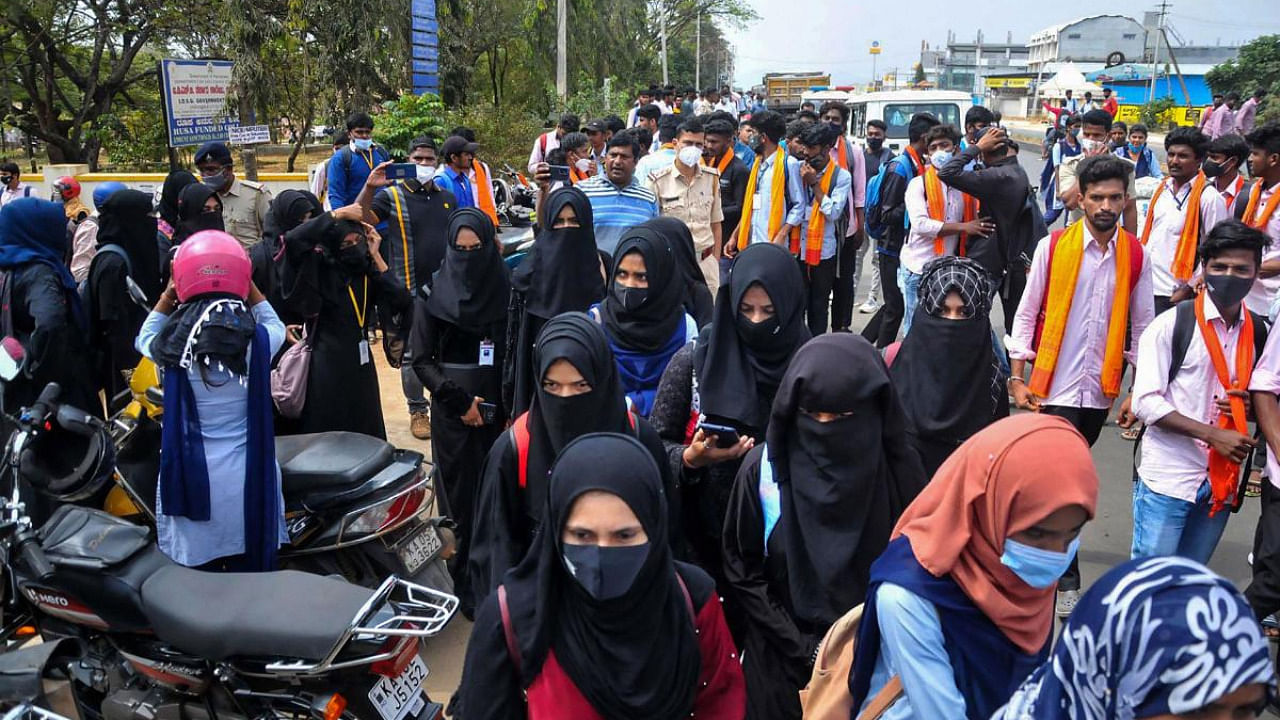 Students wearing saffron shawls stage a protest against allowance of hijab-wearing students to enter classrooms, outside IDSG Government College in Chikkamagaluru. Credit: PTI photo