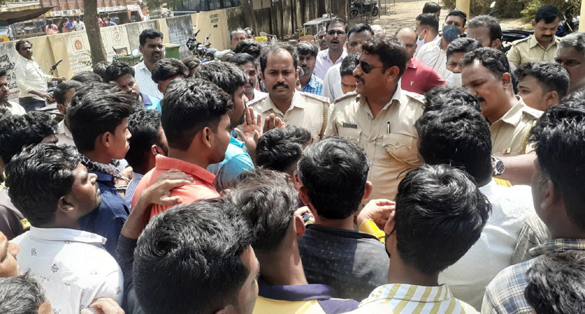 Police interact with youths after the attack in Malebennur town of Harihar taluk on Wednesday. Credit: DH Photo
