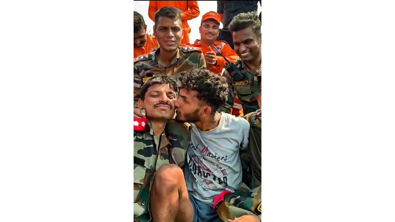 Trekker Babu, who was trapped in a steep gorge in Malampuzha mountains, kisses an Army personnel after he was rescued, in Palakkad, Kerala. Credit: PTI Photo