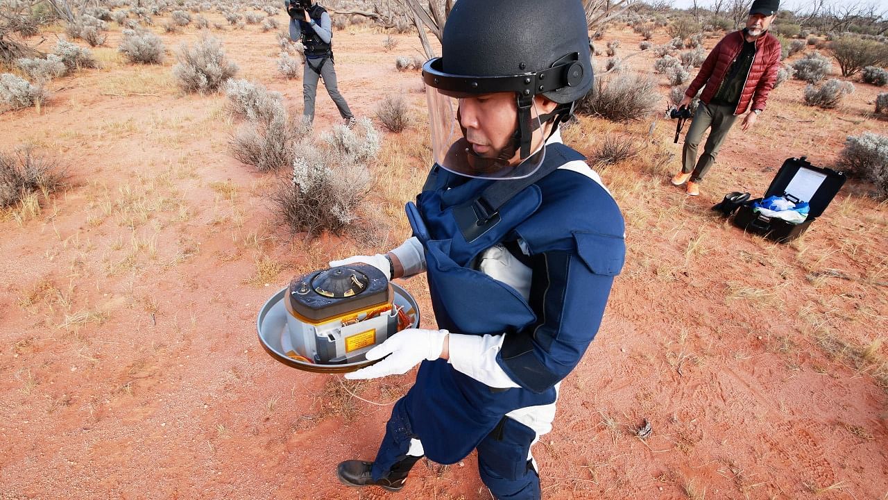 A member of JAXA collects Hayabusa2's capsule carrying the first extensive samples of an asteroid after it landed in the Woomera restricted area. Credit: Reuters Photo