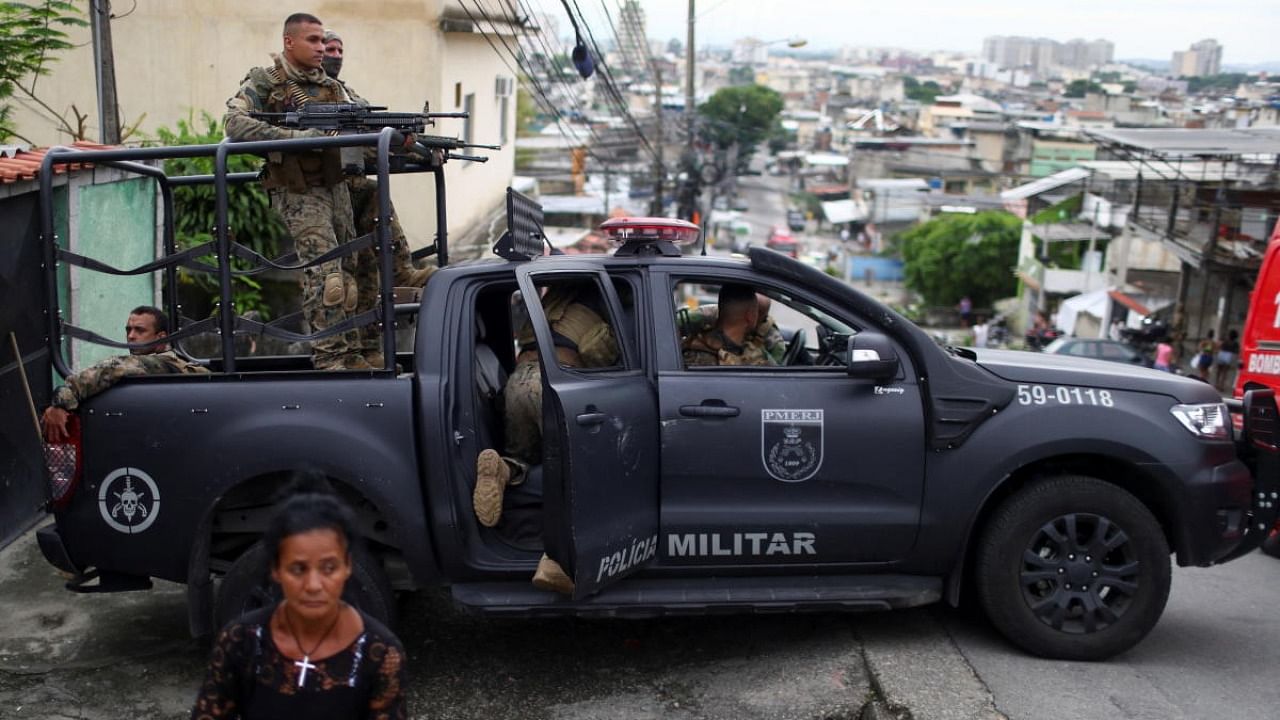 Police officers stand on a pick-up truck during an operation against drug dealers in the Penha slum complex in Rio de Janeiro, Brazil. Credit: Reuters Photo