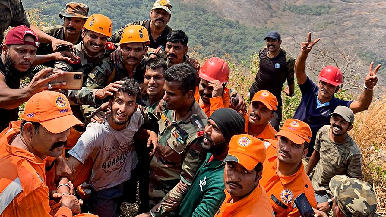 Army personnel after rescuing Babu (C), who was trapped in a steep gorge in Malampuzha mountains in Palakkad, Kerala. Credit: PTI Photo