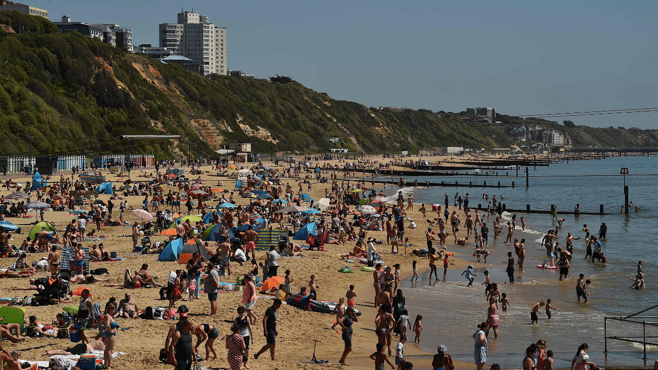 People relax in the sunshine on Bournemouth Beach in Bournemouth, southern England. Credit: AFP Photo