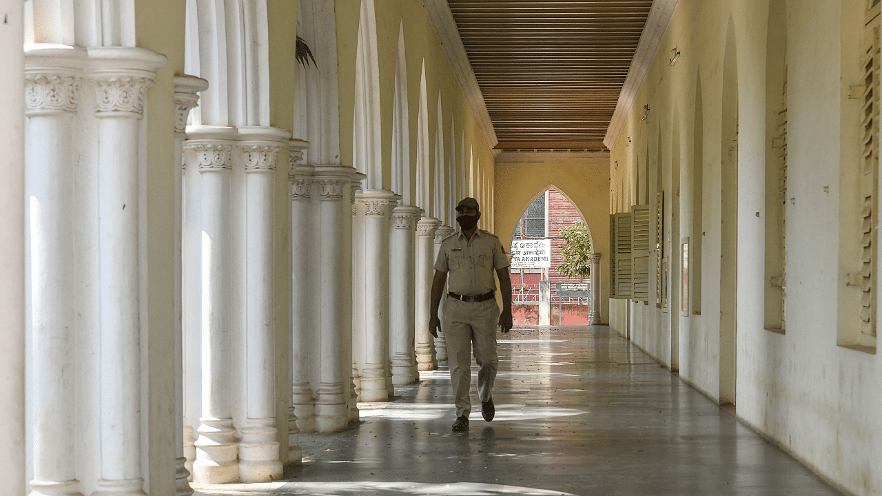 A security personnel walks inside the deserted campus of Central College as Karnataka government ordered high schools and colleges to shut. Credit: AFP Photo