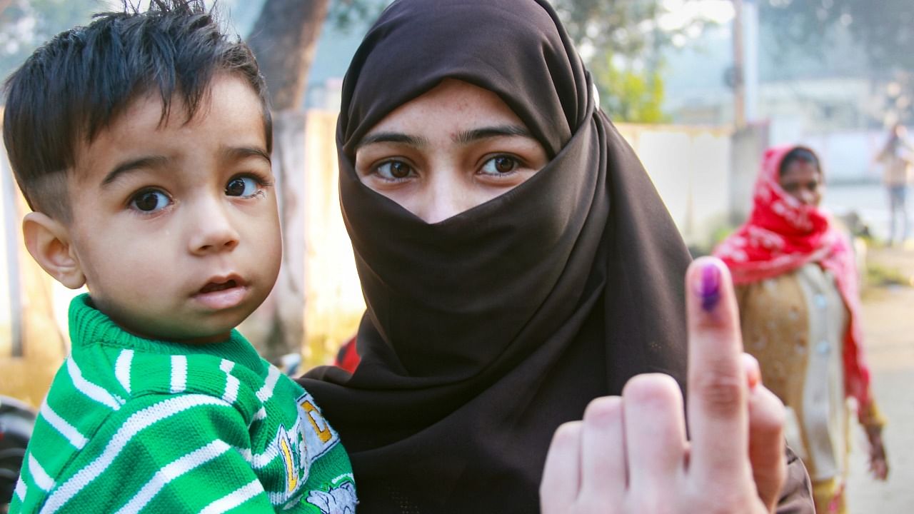 A Muslim woman shows the ink mark after casting her vote in UP. Credit: PTI Photo