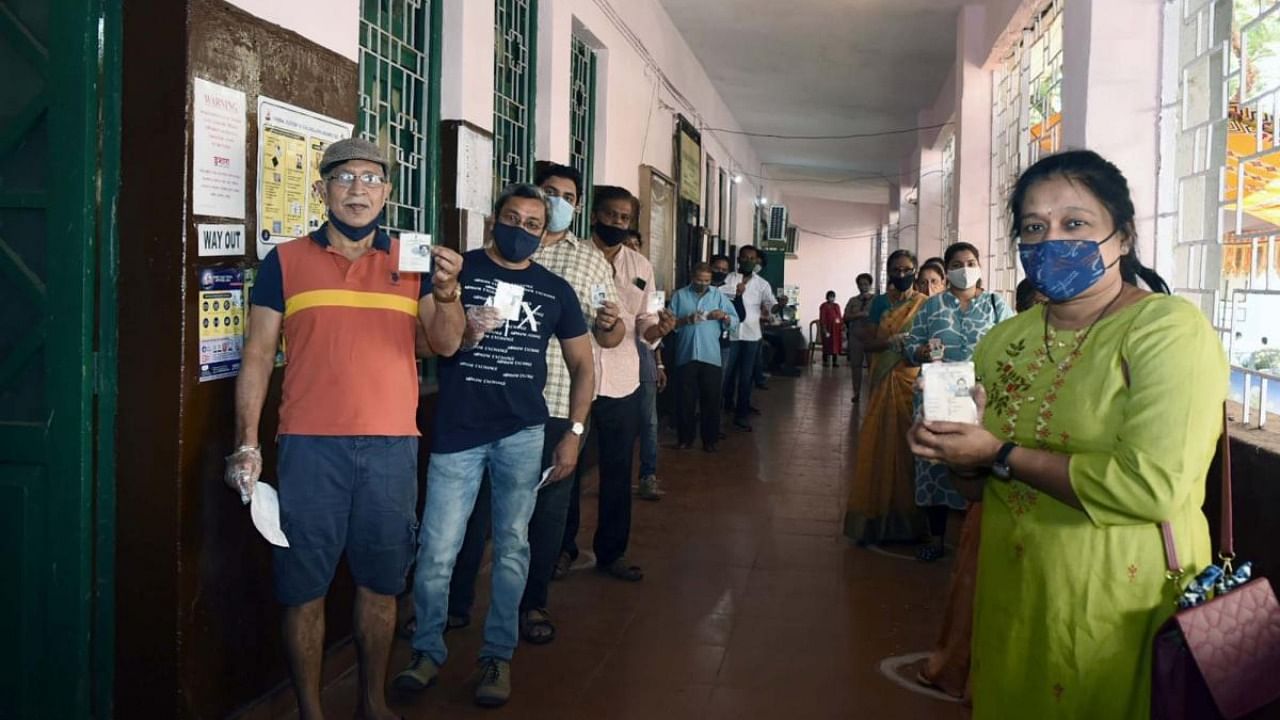 Voters stand in a queue to cast their votes at a polling booth, during the Goa Assembly Election, at Junta House in Panaji, Goa. Credit: IANS Photo