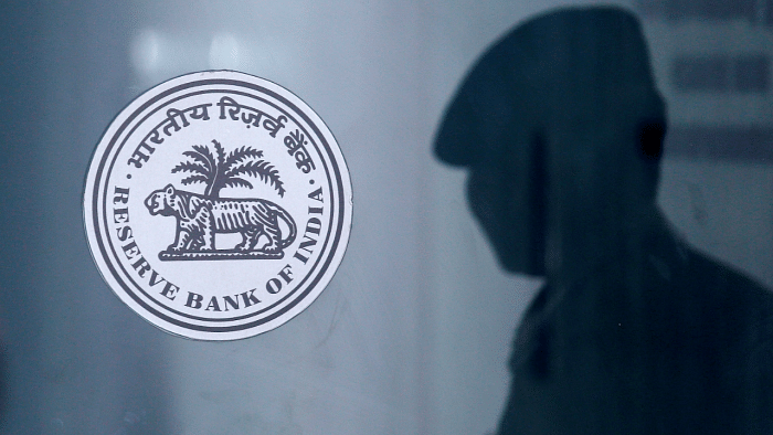 security guard's reflection is seen next to the logo of the Reserve Bank Of India (RBI) at the RBI headquarters in Mumbai. Credit: Reuters Photo