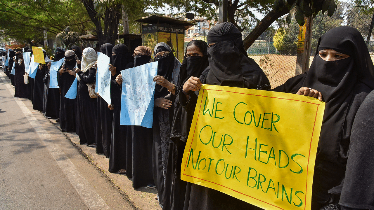 Muslim women hold placards while wearing burqa and hijab in a peaceful protest in support of female Muslim students and against the Karnataka government. Credit: PTI Photo