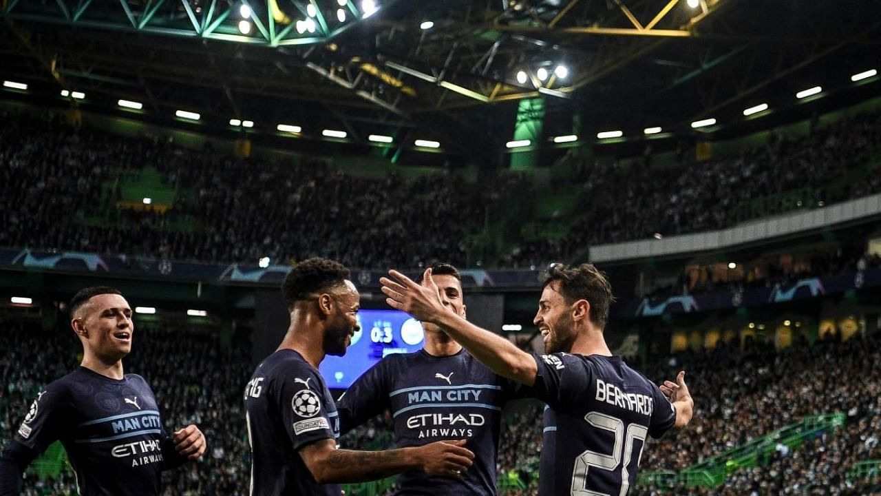 Manchester City's Portuguese midfielder Bernardo Silva (R) celebrates with teammates after scoring his team's fourth goal during the UEFA Champions League round of 16 first leg football match between Sporting CP and Manchester City at the Jose Alvalade stadium in Lisbon. Credit: AFP Photo