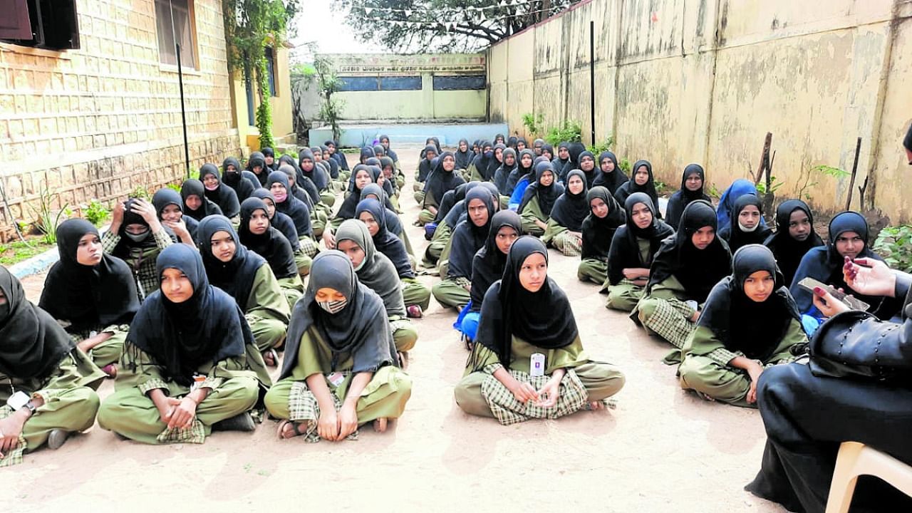 Students stage a dharna insisting that they be allowed to attend classes with hijab at government Urdu high school for girls in Gurmatkal, Yadgir district, on Tuesday. Credit: DH Photo