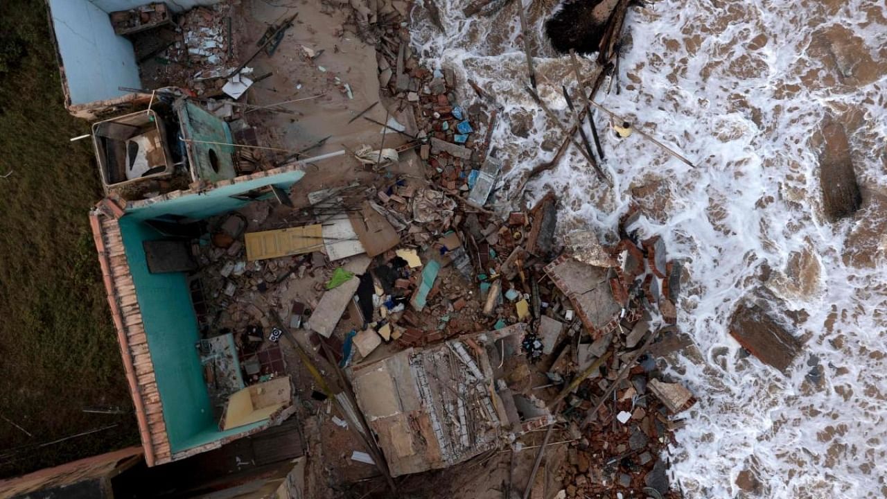 Aerial view of a man collecting debris from a house that fell the day before at Atafona beach, Atafona neighbourhood, in Sao Joao da Barra, Rio de Janeiro, Brazil, on February 7, 2022. Credit: AFP Photo