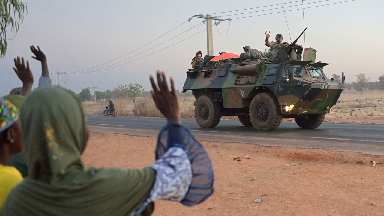 A file photo shows Malian people waving to French soldiers. Credit: AFP Photo
