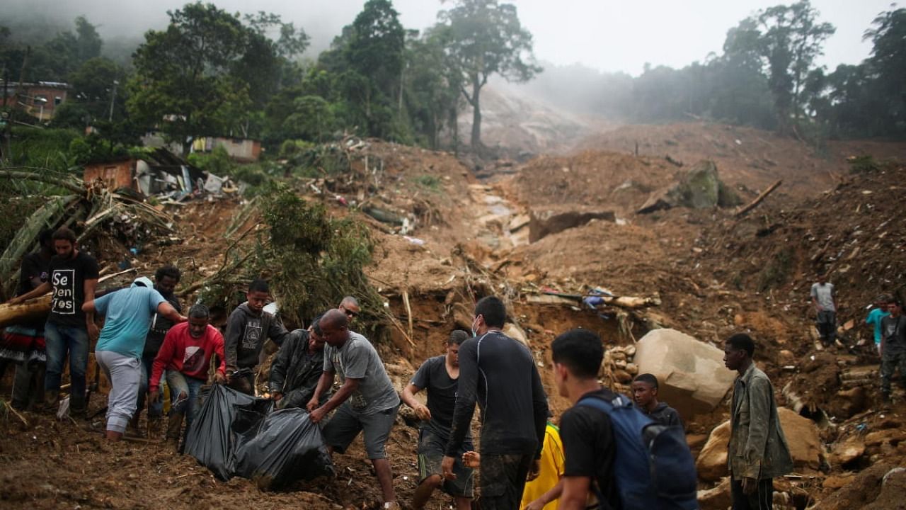 Men carry a body at a mudslide at Morro da Oficina after pouring rains in Petropolis, Brazil. Credit: Reuters Photo