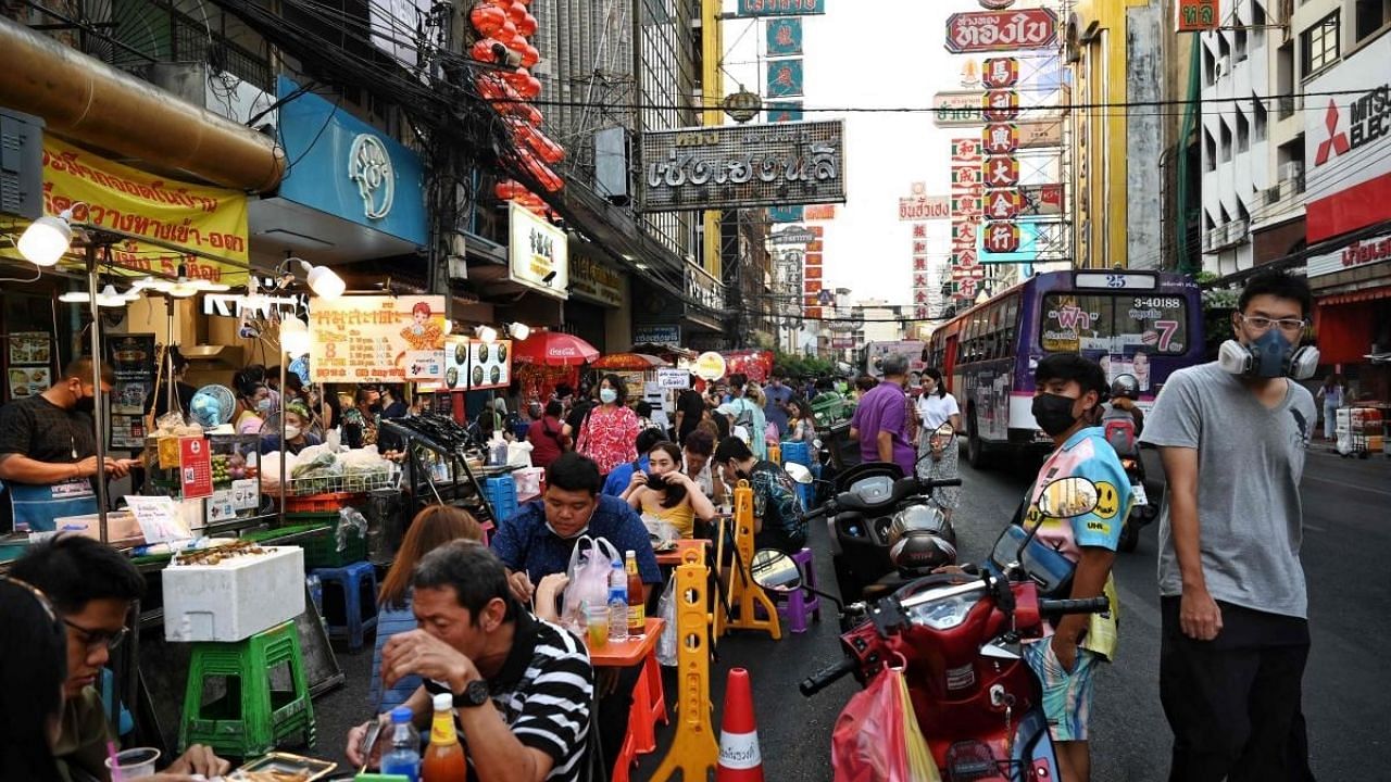 People eat at roadside food stalls in the Chinatown area of Bangkok. Credit: AFP File Photo
