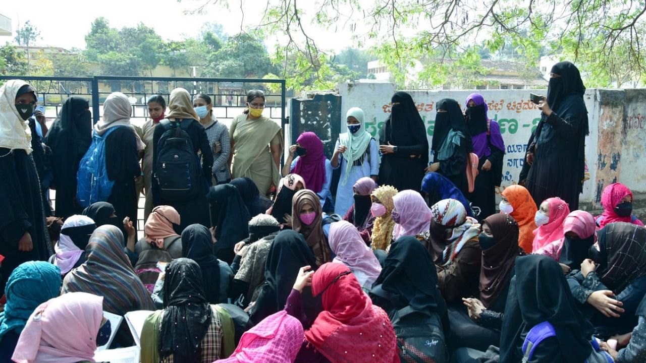 At Chitradurga Girls Government PU College, students staged a unique protest by studying outside the college premises. Credit: DH Photo