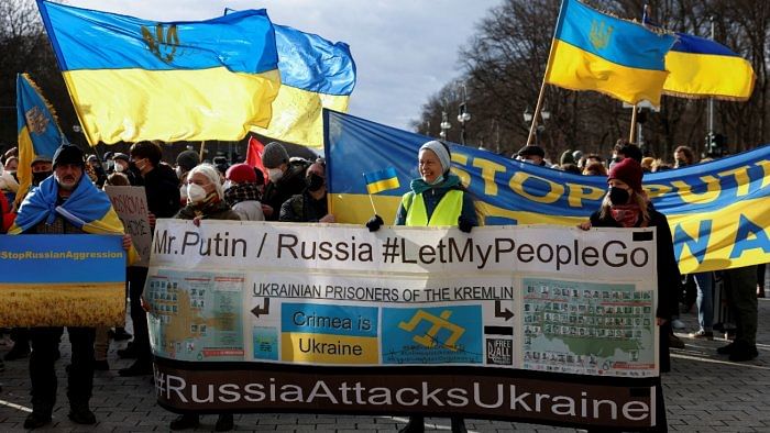 Demonstrators display banners and flags during a protest under the slogan 'Stand With Ukraine', against a possible invasion of Ukraine by Russia, in front of the Brandenburg Gate, in Berlin, Germany February 19, 2022. Credit: Reuters Photo