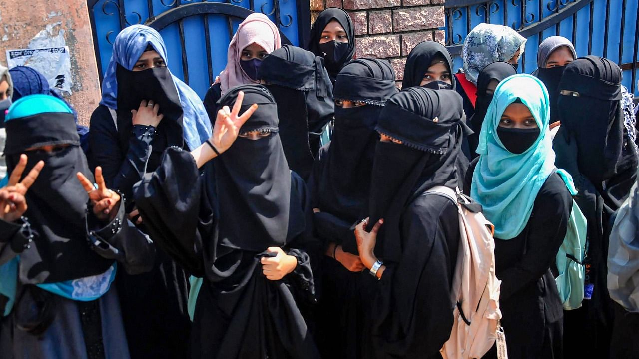  Students stand outside a college as they boycott classes after being denied entry with 'hijab' in the college premises, in Chikmagalur. Credit: PTI Photo