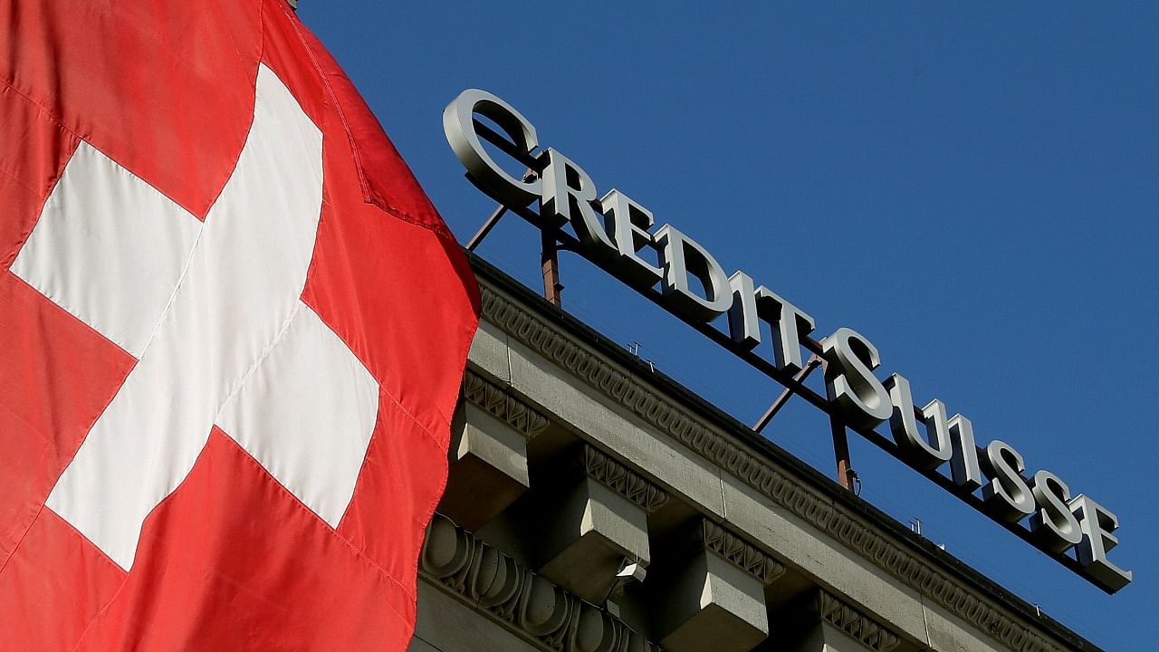 Switzerland's national flag flies next to the logo of Swiss bank Credit Suisse at a branch office in Luzern, Switzerland. Credit: Reuters File Photo
