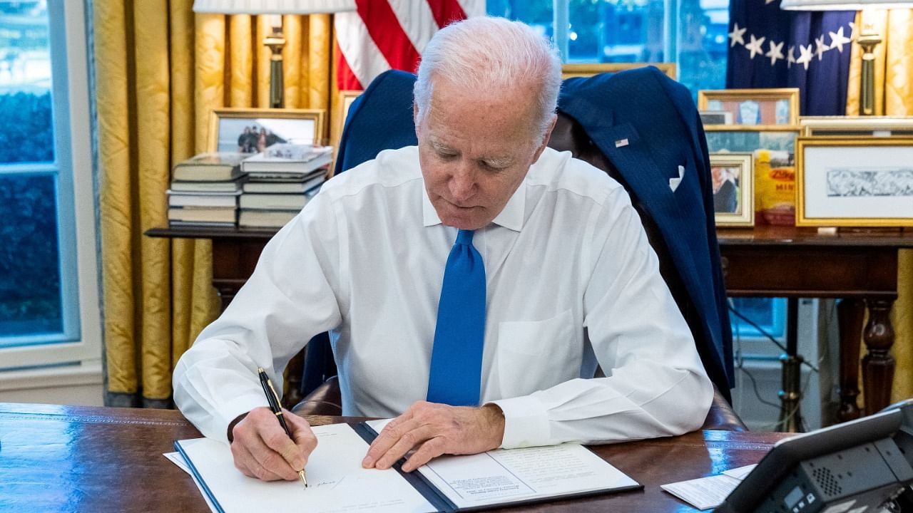 US President Joe Biden signs an executive order to prohibit trade and investment between US individuals and the two breakaway regions of eastern Ukraine recognised as independent by Russia, at the White House in Washington, US, February 21, 2022. Credit: The White House/Handout via Reuters