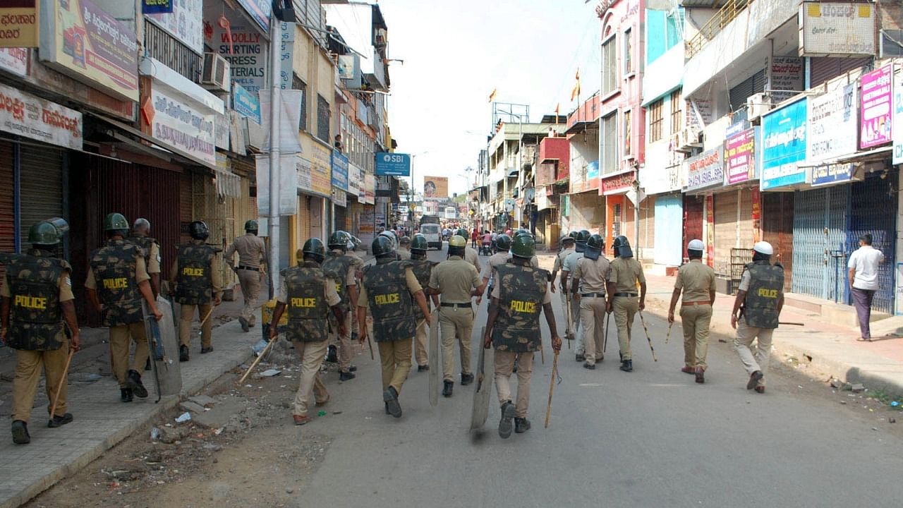 Police personnel patrolling on road as tension spread in Karnataka Shivamogga town over the murder of a fellow member on Sunday night in Shivamogga on Monday February 21, 2022. Credit: IANS Photo