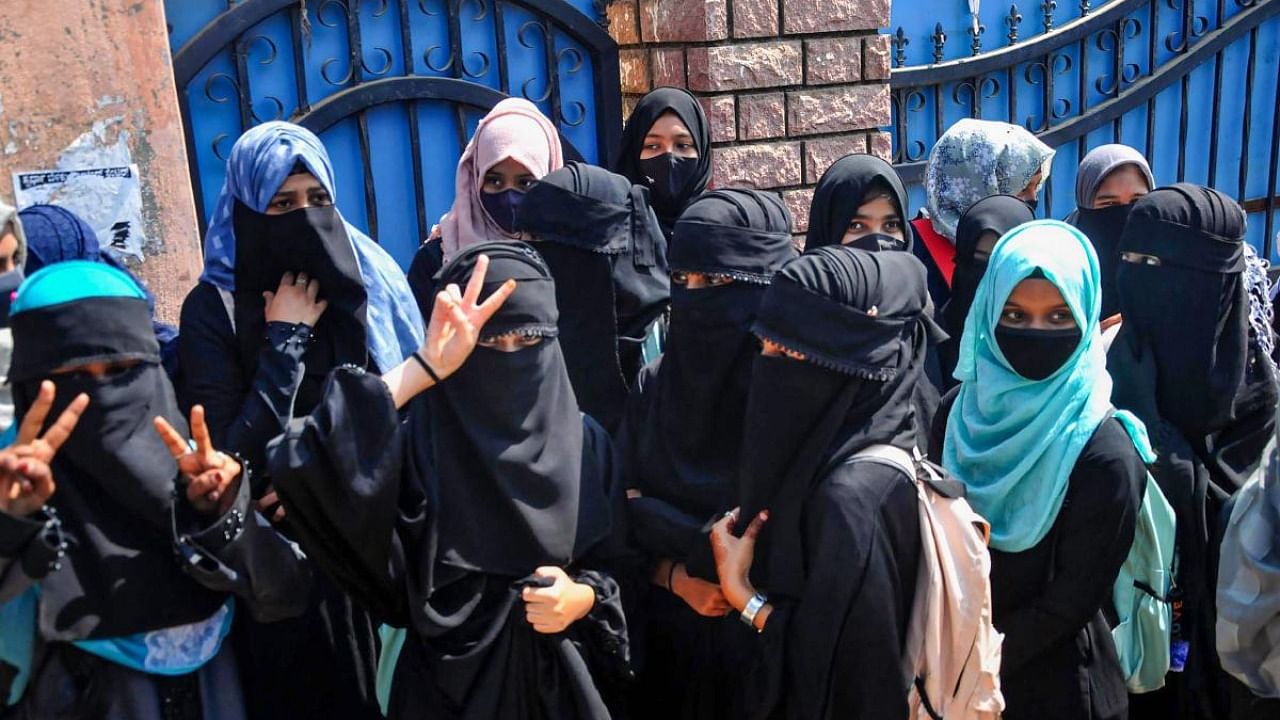 Students stand outside a college as they boycott classes after being denied entry with 'hijab' in the college premises, in Chikmagalur. Credit: PTI Photo