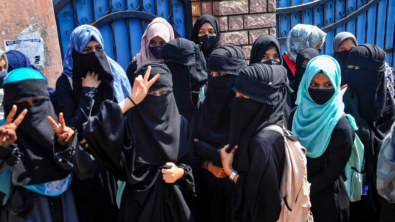 Students stand outside a college as they boycott classes after being denied entry with 'hijab' in the college premises, in Chikkamagaluru, Monday, February 21, 2022. Credit: PTI Photo