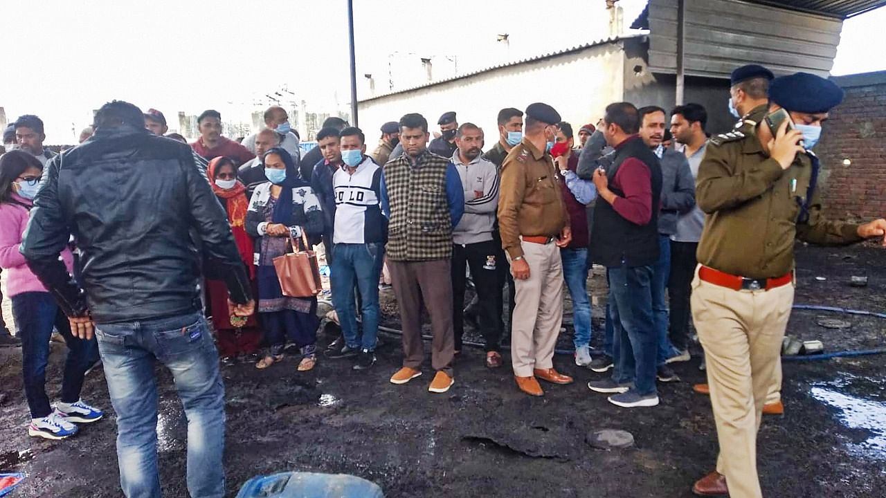 Police personnel with locals at the site after an explosion in a firecracker factory, in Una district, Tuesday, February 22, 2022. At least seven people died and 10 others were injured in the explosion, according to officials. Credit: PTI Photo