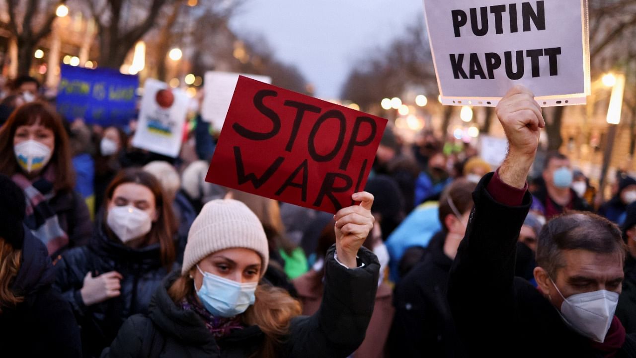 Demonstrators hold placards during an anti-war protest in front of the Russian embassy in Berlin, Germany, February 22, 2022. Credit: Reuters Photo