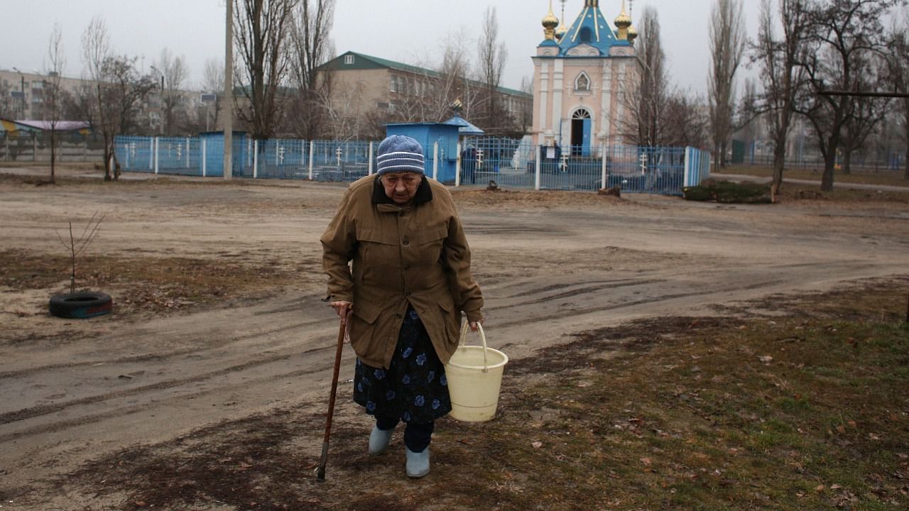 Residents collect water from a well in the town of Schastia, near the eastern Ukraine city of Lugansk, on February 23, 2022, after the town's pump stations were knocked out of power by shelling. Credit: AFP Photo