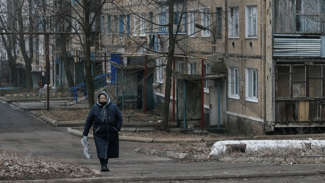 Local resident walks along a street near the front line near the city of Novoluhanske. Credit: Reuters Photo