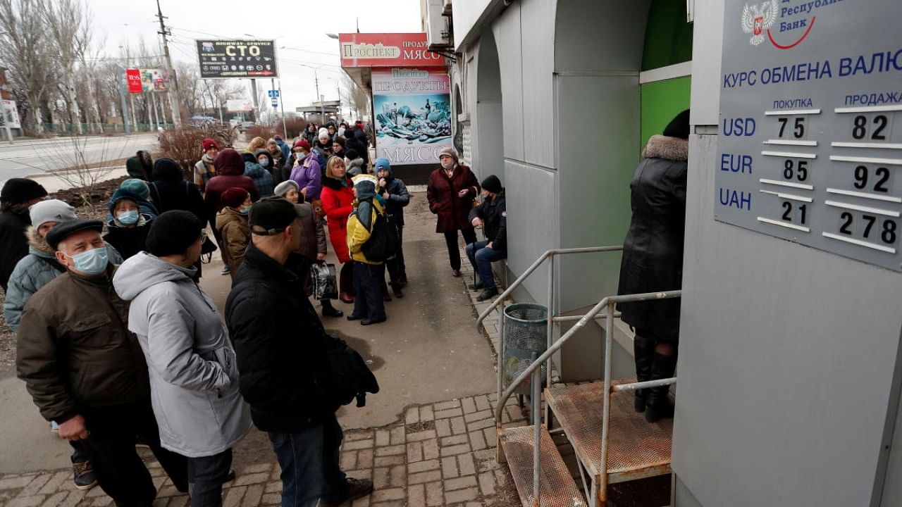 People stand in line to use an ATM money machine, after Russian President Vladimir Putin authorized a military operation in eastern Ukraine, in the separatist-controlled city of Donetsk, Ukraine. Credit: Reuters Photo