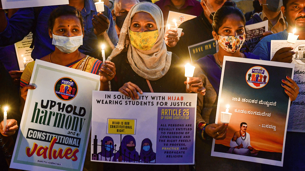 Citizens hold placards and candles in support of the hijab wearing students, in Bengaluru. Credit: PTI Photo