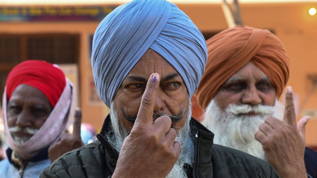 Voters show their inked finger after casting ballot at a polling station in a village on the outskirts of Amritsar. Credit: AFP File Photo
