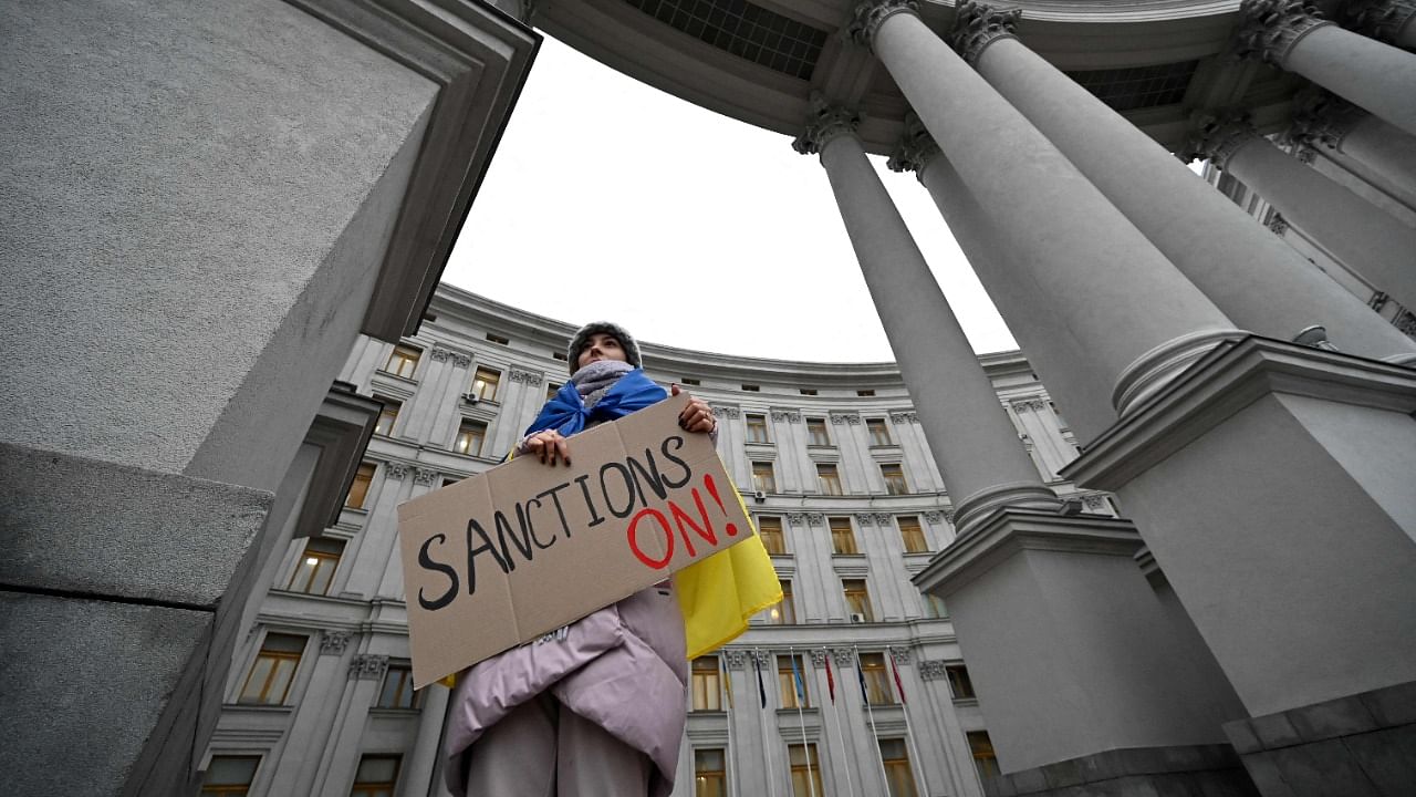 A protester holds a placard seeking sanctions against Russia. Credit: AFP Photo
