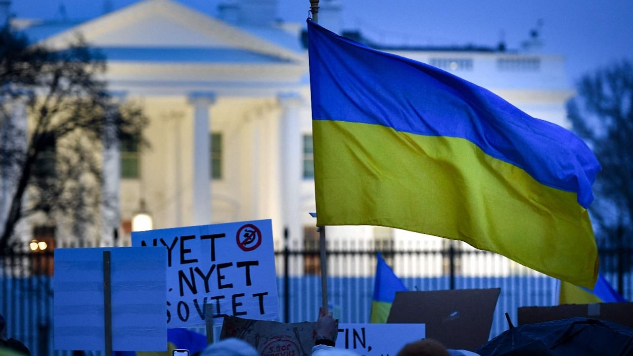 An activist holds the Ukraine national flag while protesting against the Russian invasion of Ukraine, in Lafayette Square in Washington, DC. Credit: AFP Photo