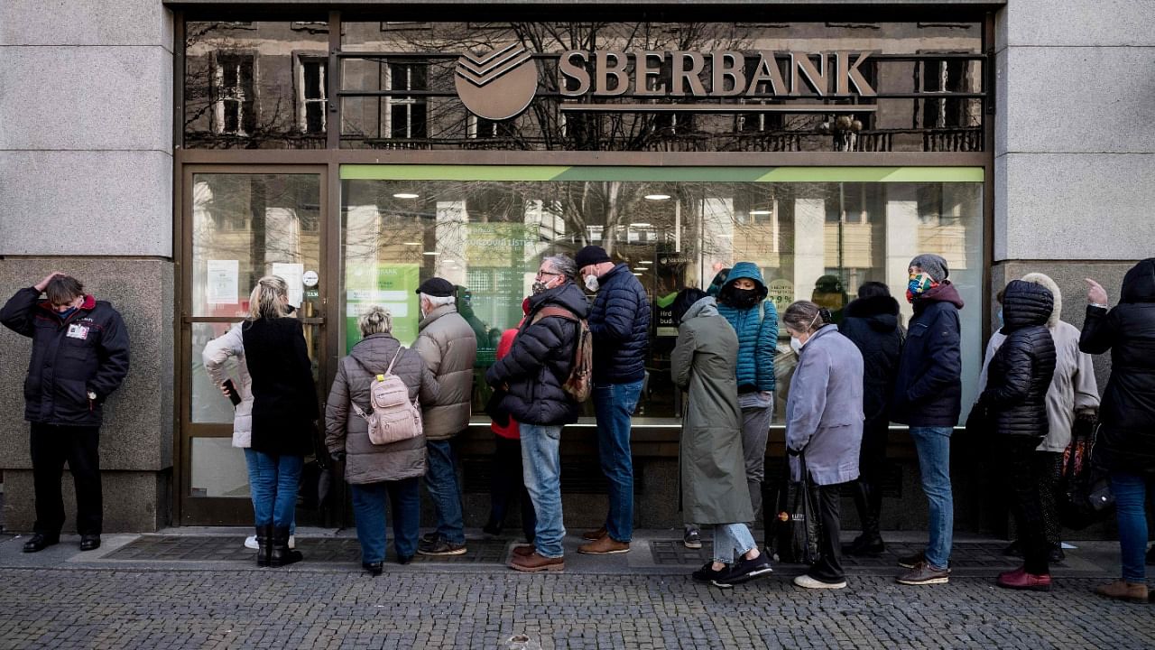 People queue outside a branch of Russian state-owned bank Sberbank to withdraw their savings and close their accounts in Prague. Credit: AFP Photo