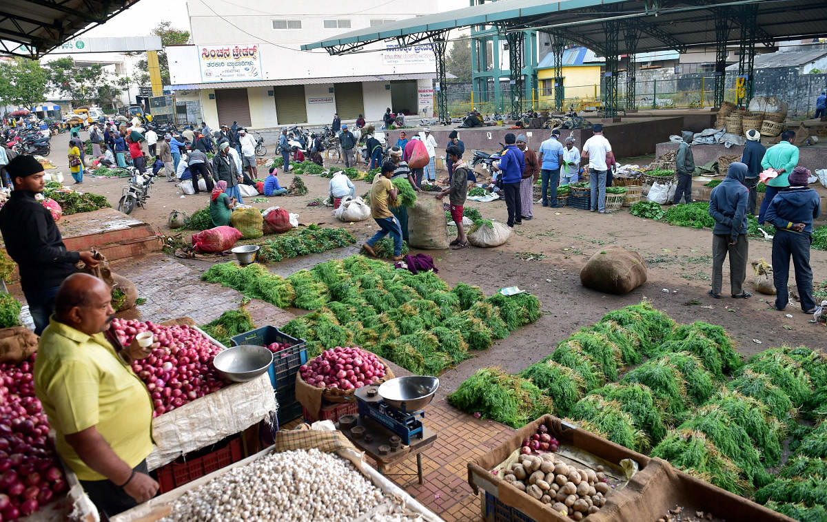 People visit a wholesale vegetable market after Section 144 was lifted by authorities in Shivamogga on Saturday. Credit: PTI Photo