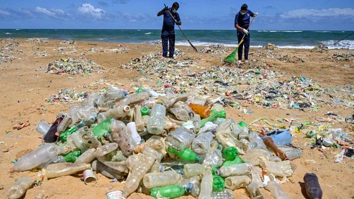 In this file photo taken on June 05, 2020 Police Environmental Protection Division officers take part in a beach clean-up effort to remove waste and garbage on the United Nations' World Environment Day at Mount Lavinia on the outskirts of Colombo. Credit: AFP Photo