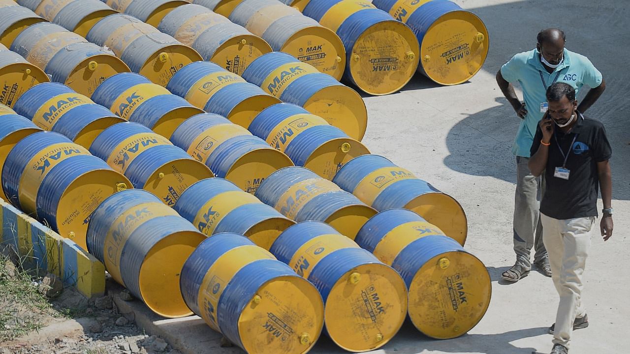 Workers walk past oil barrels at a filling station in n Chennai. Credit: AFP File Photo