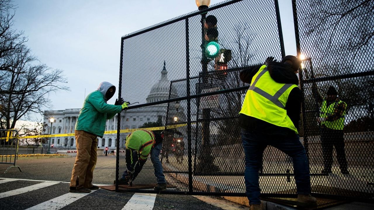 Workers install security fencing around the perimeter of the US Capitol, ahead of the upcoming State of the Union with President Joe Biden. Credit: Reuters photo