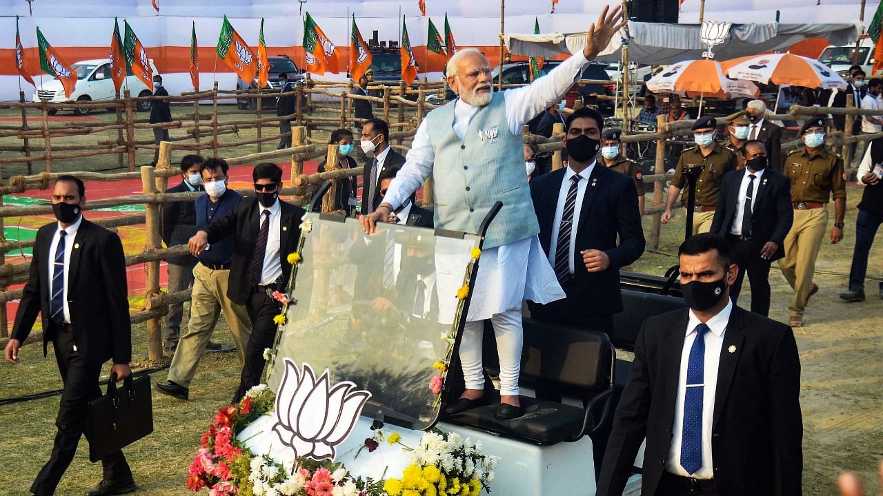 Prime Minister Narendra Modi waves towards supporters as he arrives at the 'Booth Vijay Sammelan' for the ongoing Uttar Pradesh Assembly elections, in Varanasi. Credit: PTI Photo