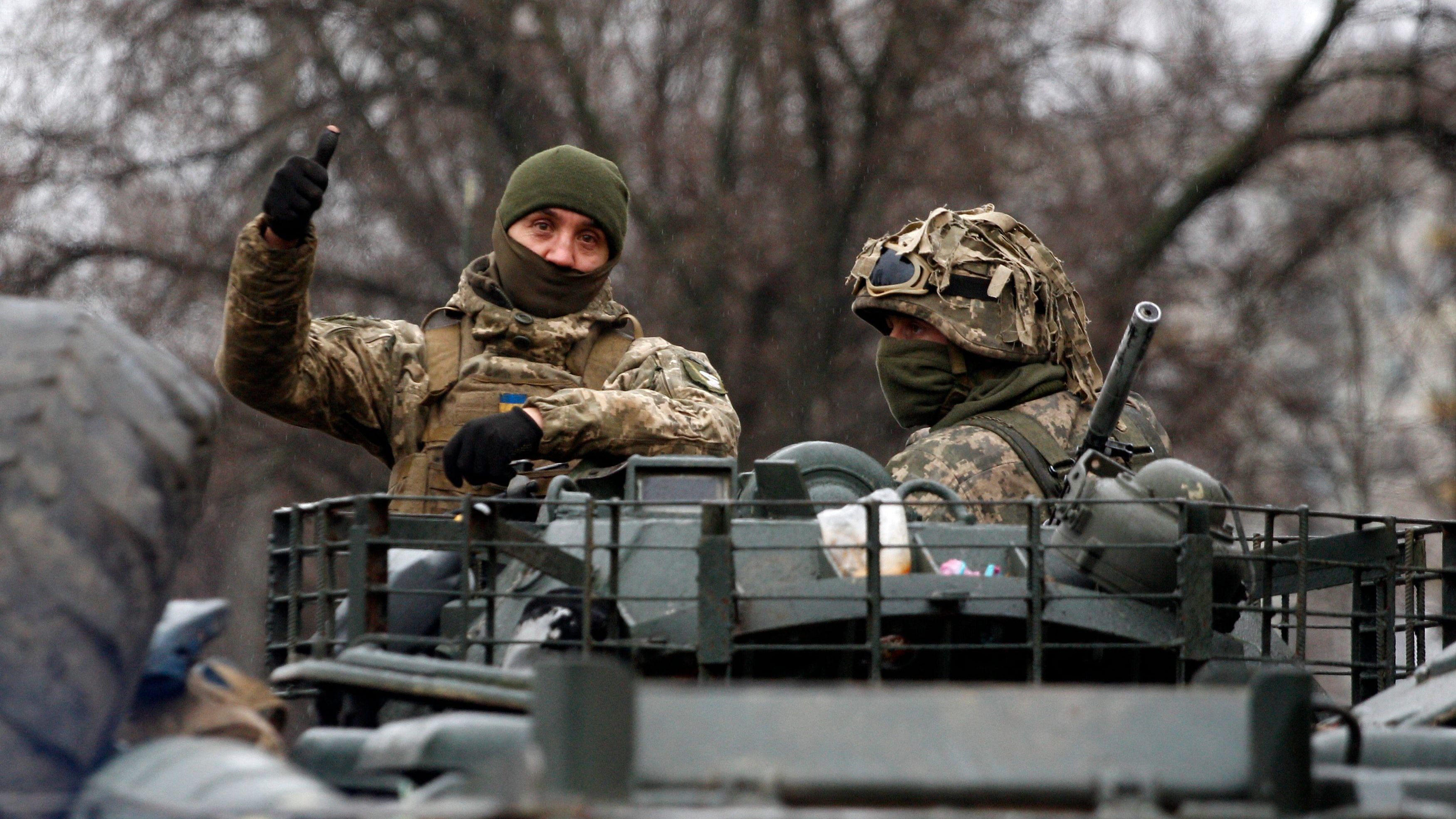 A Ukrainian serviceman gives a thumb up riding atop a military vehicle before an attack in Lugansk region on February 26. credit: AFP Photo