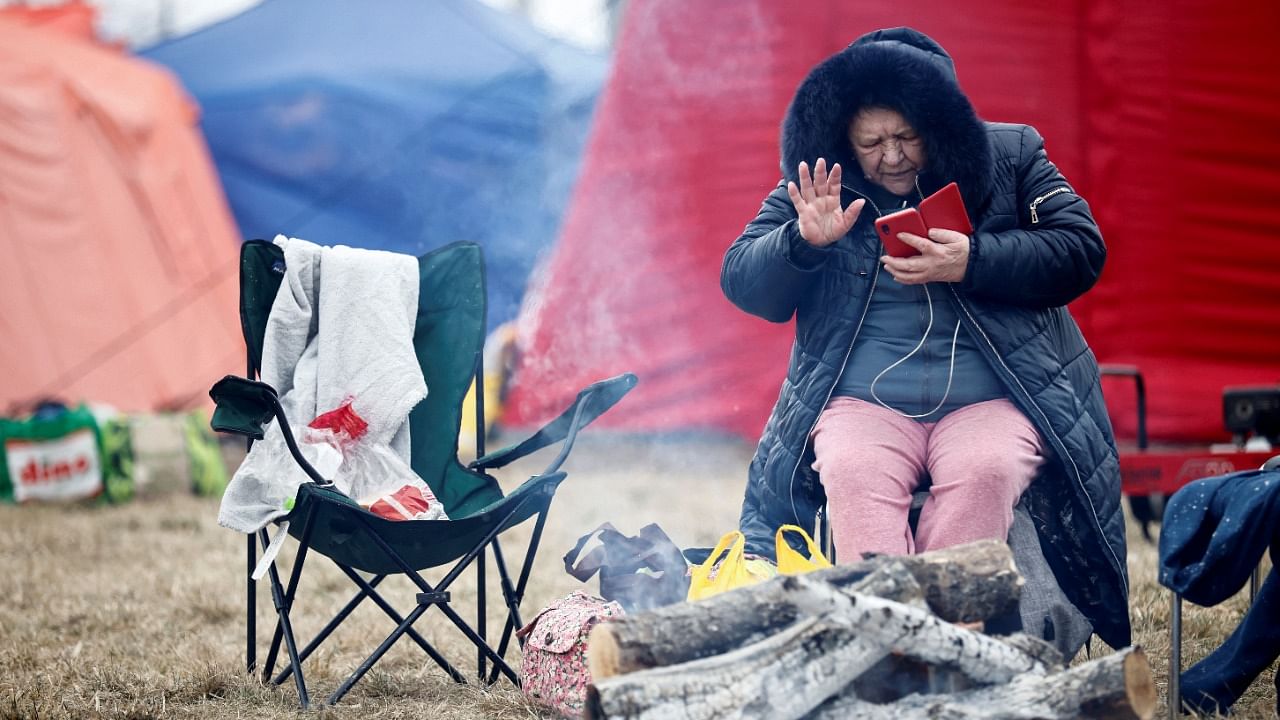 A woman fleeing Russian invasion of Ukraine sits at a temporary camp in Przemysl, Poland. Credit: Reuters photo